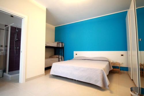 カザラーノにあるB&B Le Parmenteの青い壁のベッドルーム1室(ベッド1台付)