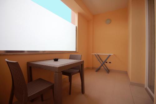 カザラーノにあるB&B Le Parmenteのテーブルと椅子、窓が備わる客室です。