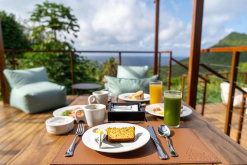 un tavolo con piatti di cibo e bevande su un balcone di Pousada Grega Noronha a Fernando de Noronha