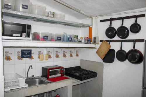 a small kitchen with a stove and a sink at The Boat House Cancun in Cancún