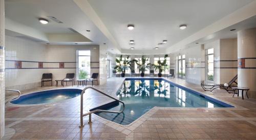 a large swimming pool in a large building at Hilton Garden Inn Montreal Airport in Dorval