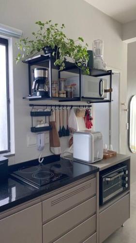 a kitchen with a counter top with a stove top oven at Kitnet equipada e aconchegante in Passos
