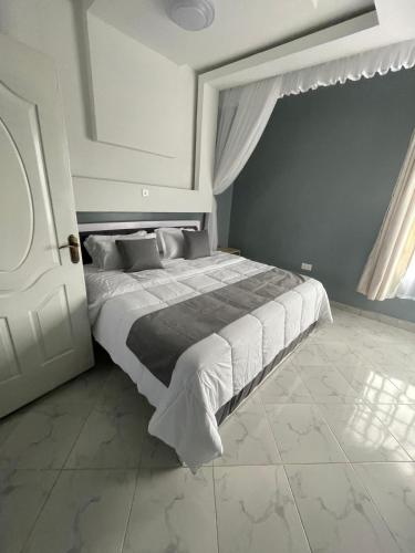 a bedroom with a large bed with white sheets at Mavana Cottages in Ol Pejeta Conservancy