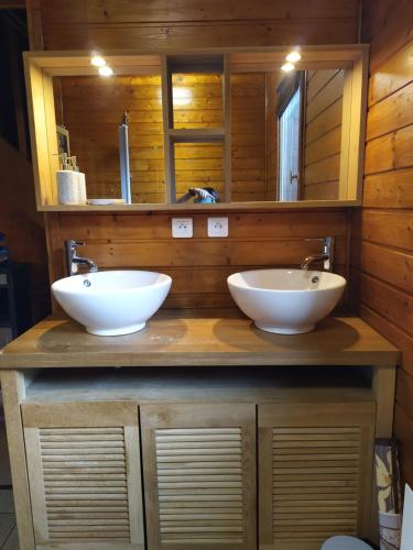 - une salle de bains avec deux lavabos sur un comptoir en bois dans l'établissement Chalet Gîte Belle Ile en Lormes, à Lormes