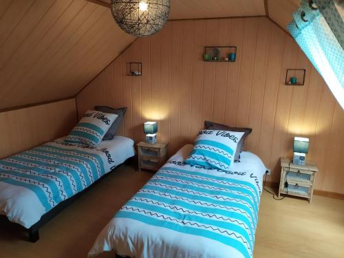 deux lits dans une chambre avec deux lampes dans l'établissement Chalet Gîte Belle Ile en Lormes, à Lormes