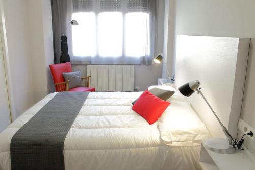 a bedroom with a large bed with red pillows at Bressol B&B in Ripoll