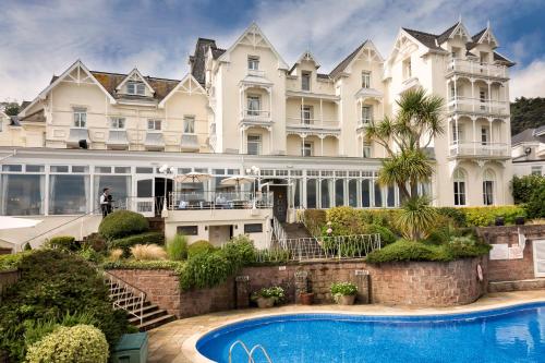 a large white building with a swimming pool in front of it at Somerville Hotel in Saint Aubin