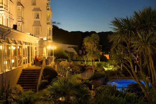 a night view of a building with a swimming pool at Somerville Hotel in Saint Aubin
