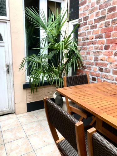 une table et des chaises en bois sur une terrasse dans l'établissement Studio autonome terrasse privée, à Tourcoing