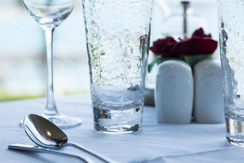 a table with a glass of water and a spoon at Somerville Hotel in Saint Aubin