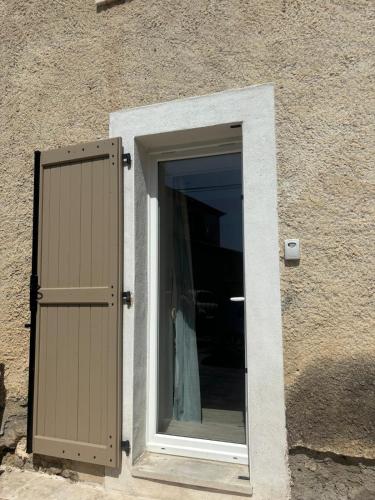 - une fenêtre dans un bâtiment avec une porte dans l'établissement Studio avec piscine, à Nîmes