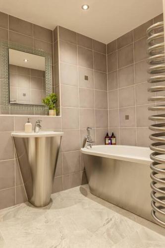 a bathroom with a tub and a sink and a bath tub at Elegant City Centre Apartment 2 Bedroom With Free Parking in Cardiff