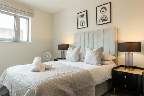 a bedroom with a large bed with white sheets and pillows at Elegant City Centre Apartment 2 Bedroom With Free Parking in Cardiff