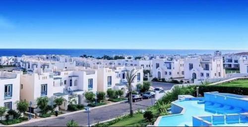 a view of a city with white houses and the ocean at Luxury Twin Villa in Mountain View Ras Elhikma in Ras Elhekma