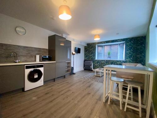 a kitchen and living room with a sink and a table at Apartment 1 in Manchester