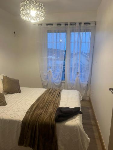 une chambre avec un lit et deux grandes fenêtres dans l'établissement Appartement a louer, au Havre
