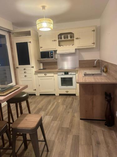 une cuisine avec des armoires blanches et une table et des chaises dans l'établissement Appartement a louer, au Havre