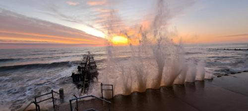 a boat in the ocean with the sunset in the background at The Stable in Overstrand