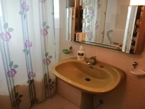 a bathroom with a sink and a shower curtain at Nansy's house in Áyios Pávlos
