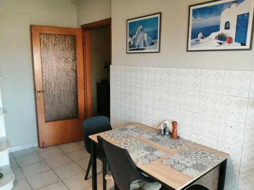 a dining room with a table and chairs and a door at Nansy's house in Áyios Pávlos