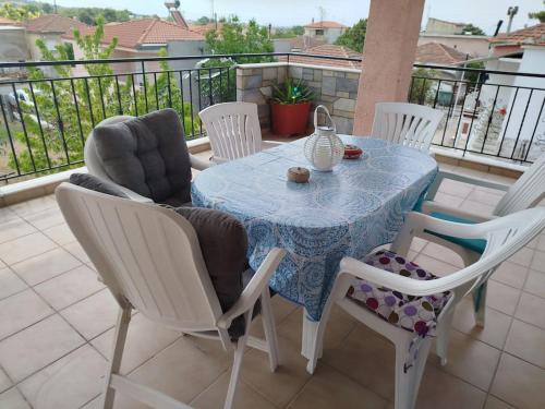 a table and chairs on a balcony with a table at Nansy's house in Áyios Pávlos