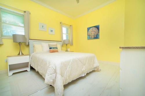 a bedroom with a bed and a yellow wall at On The Bay in North Side