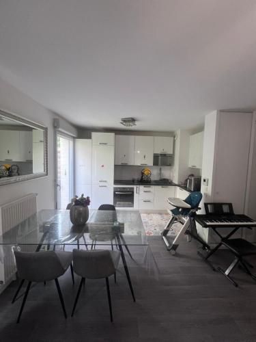 un salon avec une table en verre et des chaises dans l'établissement Maison de 100m2 a 5 minutes du centre de base du PSG, à Poissy