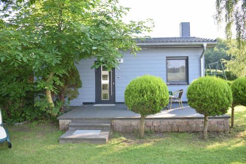 a house with a porch with a table and chairs at Hotel Seeschlösschen in Groß Köris