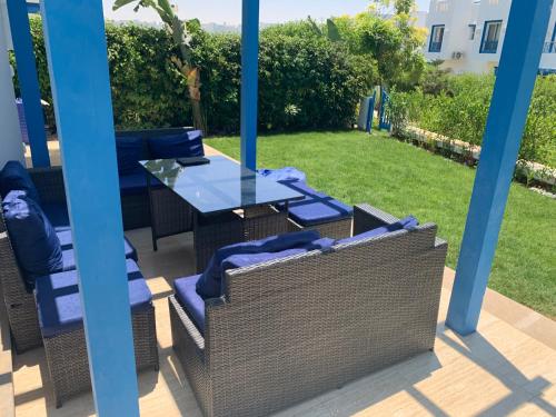 a gazebo with chairs and a glass table at Luxury Twin Villa in Mountain View Ras Elhikma in Ras Elhekma