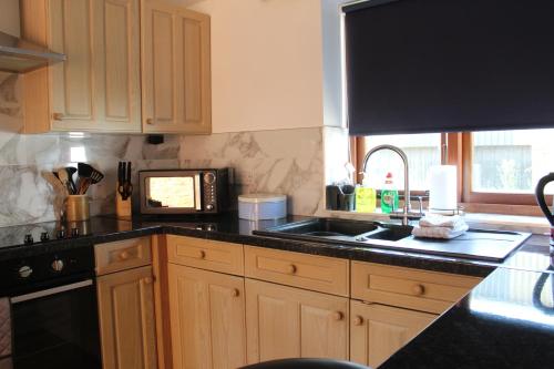 a kitchen with a sink and a microwave at Parkfields Barns Self Catering Accommodation in Buckingham
