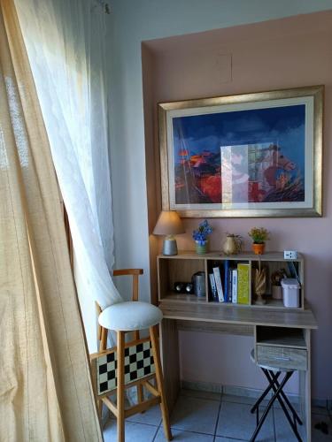 a desk with a chair next to a window at VILLA APHRODITE SOUGIA apt1 in Kamária