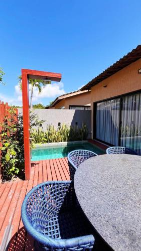 a patio with a table and chairs and a pool at Fontes da Pipa by Liiv in Pipa