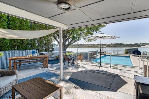 a patio with a table and an umbrella and a pool at Fish, Swim, Relax Moses Lake Gem with Outdoor Oasis in Moses Lake