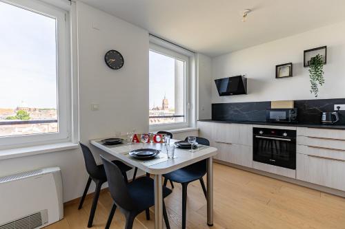 une cuisine avec une table et des chaises dans une pièce dans l'établissement Appartement cosy Place des Halles - Hyper centre, à Strasbourg