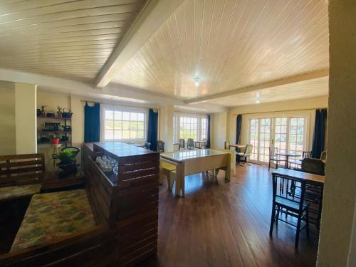 a large living room with a table and chairs at Betume in Campos do Jordão