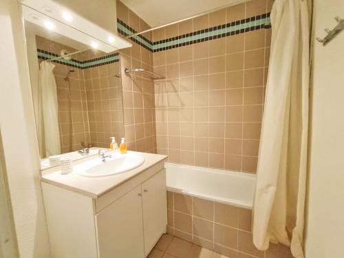 a bathroom with a sink and a bath tub at La Bicyclette, T2, wifi, parking, balcon, 4 personnes in Luchon