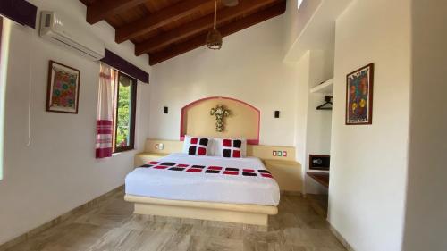 ein Schlafzimmer mit einem großen weißen Bett in einem Zimmer in der Unterkunft Villas Sunrisa in Zihuatanejo