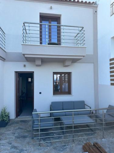 a white building with a balcony and a couch at La vie luxury suites in Megalochori