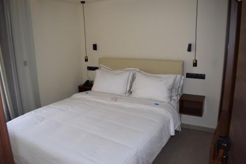 a bedroom with a white bed with white sheets and pillows at La vie luxury suites in Megalochori