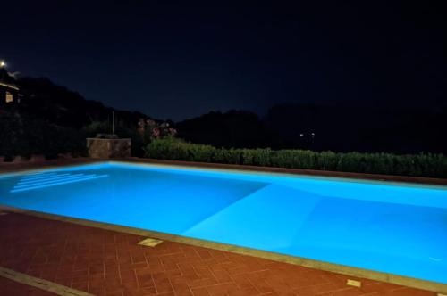 a swimming pool at night with blue lighting at Strepitoso 4 Camere da letto e Terrazza Vista Mare in Capo Coda Cavallo