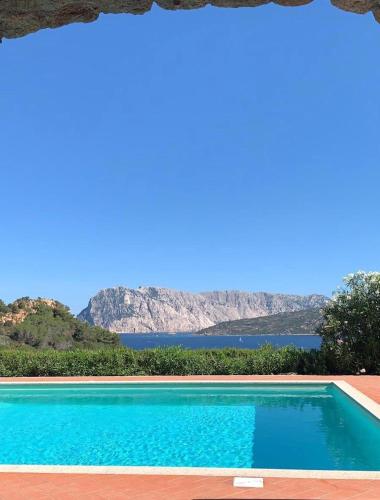 a swimming pool with a view of the water and mountains at Strepitoso 4 Camere da letto e Terrazza Vista Mare in Capo Coda Cavallo