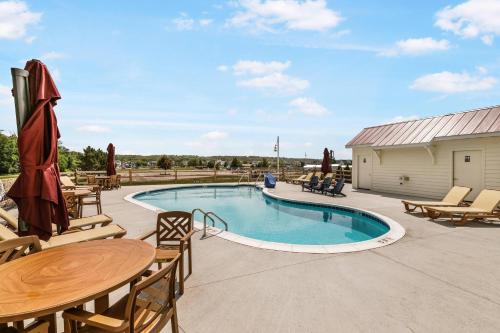 a patio with a pool and tables and chairs at Just a Little Longer in Ottawa