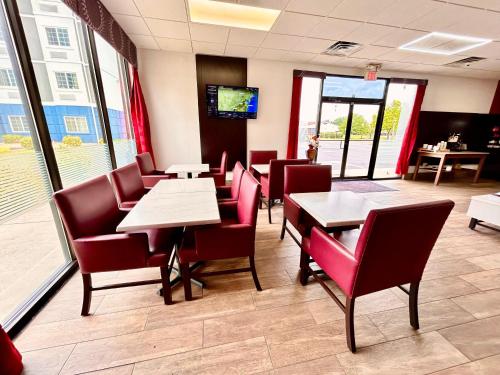 a dining room with tables and chairs and a tv at Ramada by Wyndham Harrisonburg in Harrisonburg