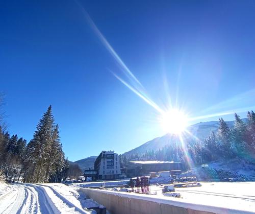 a sun is shining over a snow covered mountain at Oaza in Sarajevo