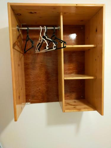 a wooden book shelf with someones shoes in it at Les Naïades in Goyave