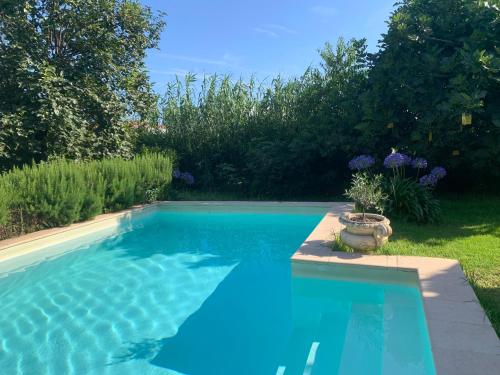 une grande piscine bleue dans une cour dans l'établissement La campagne en ville piscine, jardins et 2 chambres tout confort, à Nice