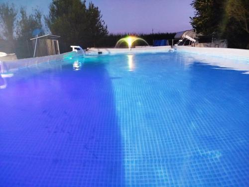 a large blue swimming pool at night at Spighe Paglia e Girasole in Candia Canavese