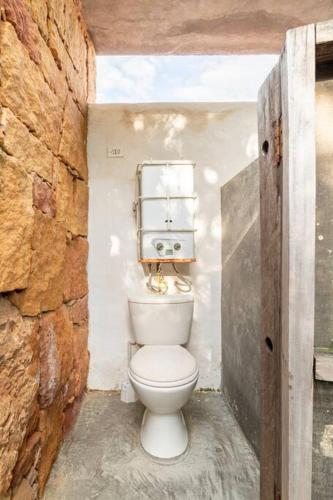a bathroom with a toilet in a stone wall at Casa Loft en Corazón de Barichara in Barichara