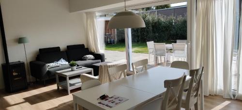 a living room with a couch and a table and chairs at Sterrenhemel in Kamperland