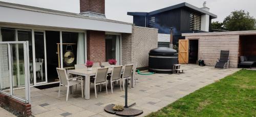 a patio with a table and chairs in a yard at Sterrenhemel in Kamperland